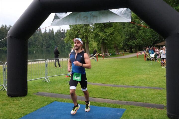 An athlete runs across the finish line at Lake Wilderness Triathlon, one of the best 2025 sprint and Olympic races in the U.S.