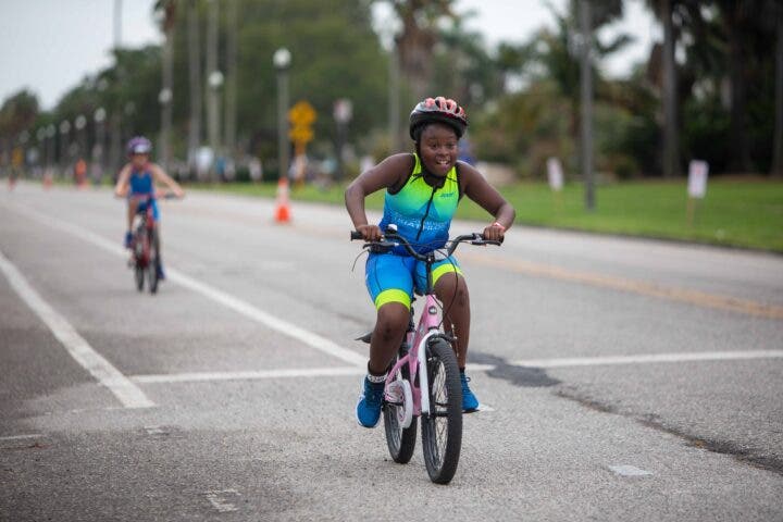 A young triathlete races the Meek & Mighty Triathlon, one of the best triathlon races for beginners.