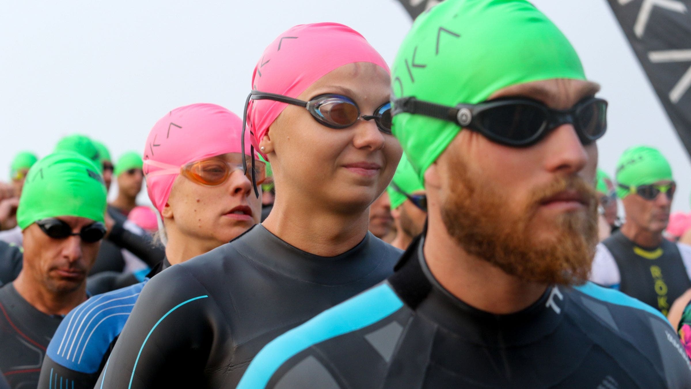 A triathlete prepares to start while asking How do I know I'm ready for a triathlon swim?