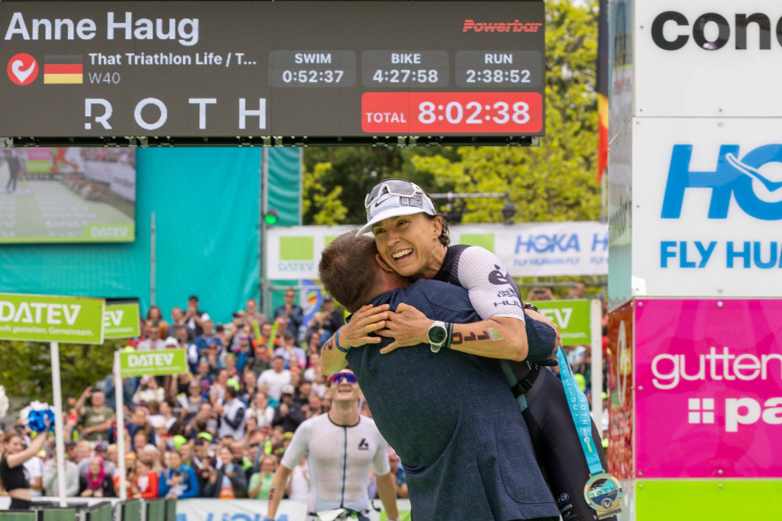 Anne Haug celebrates at the 2024 Challenge Roth finish line after setting the record for fastest Iron distance triathlon