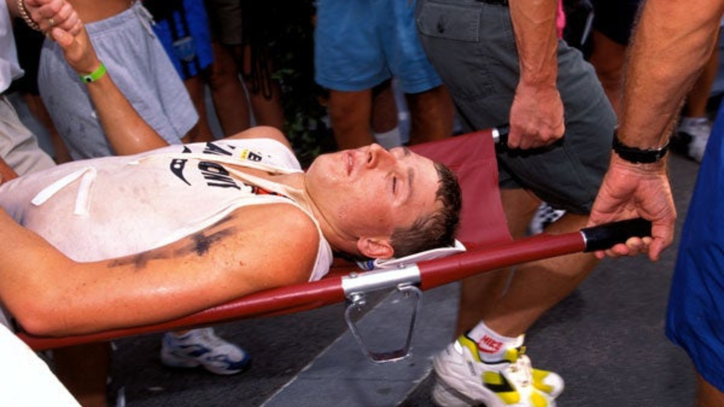 man in tri kit is carried away in a stretcher