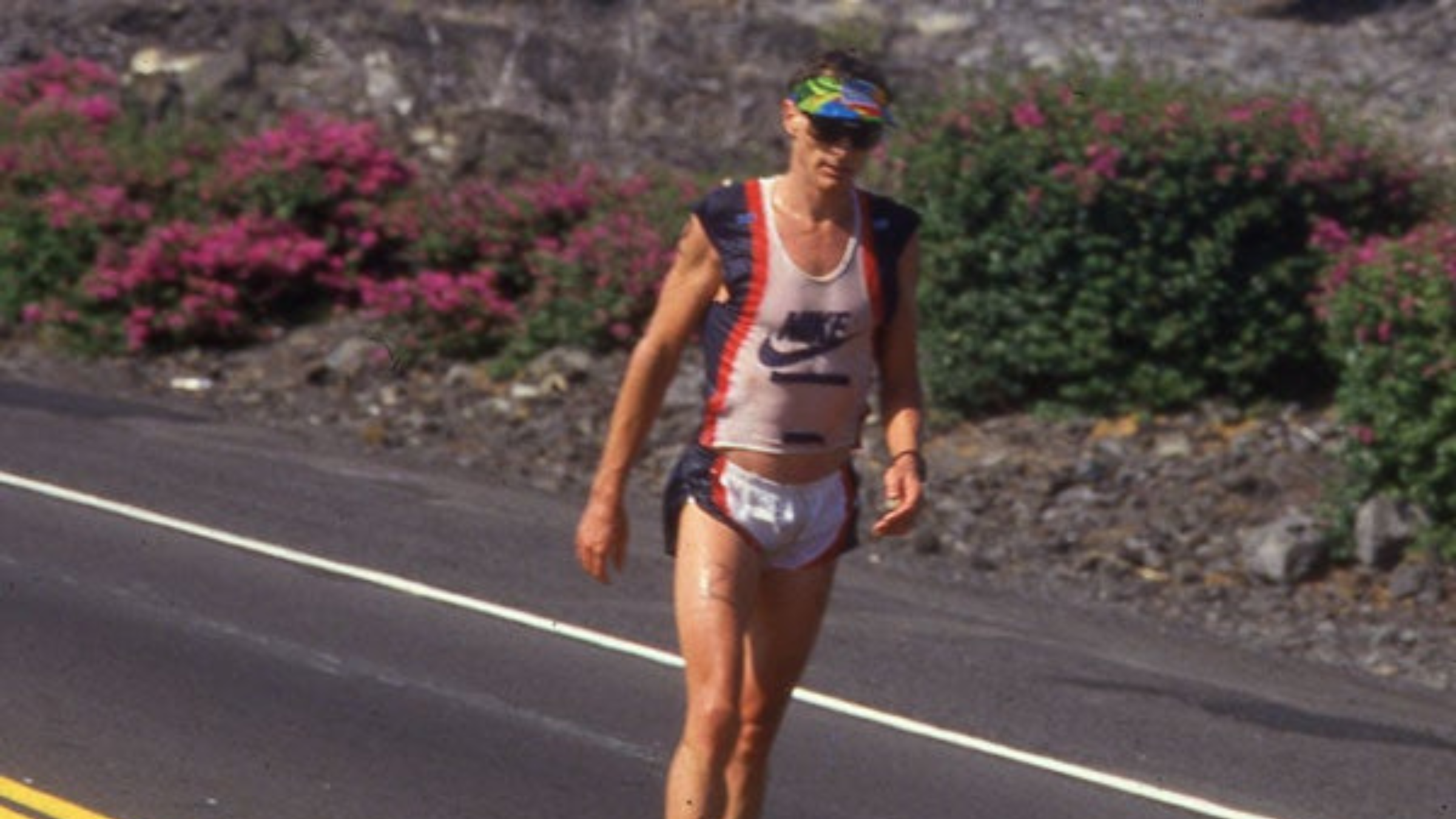 man in 1980s triathlon attire walks down the road in 1987 Ironman World Championship