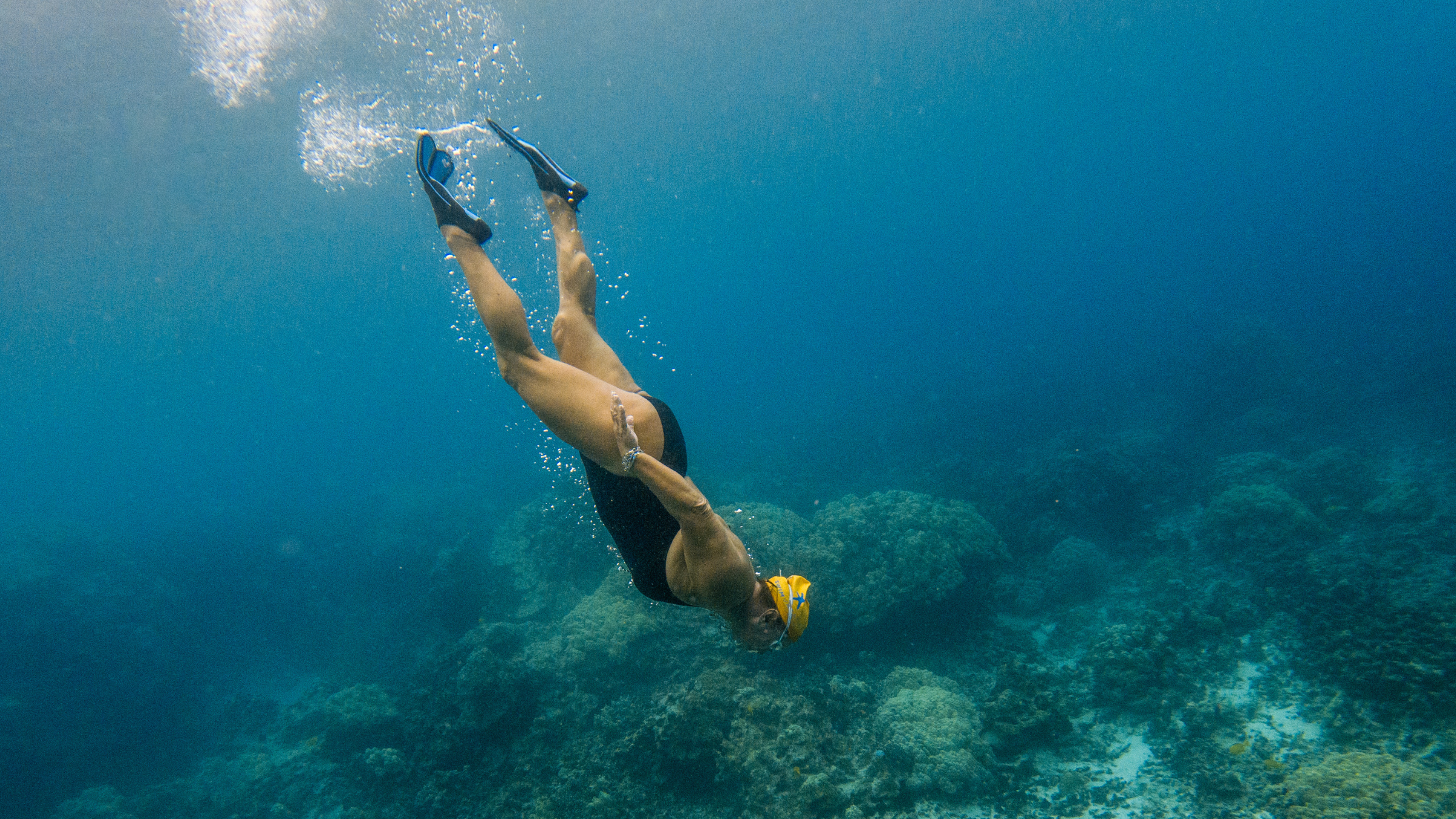 Woman swimming underwater with flippers during swim vacation