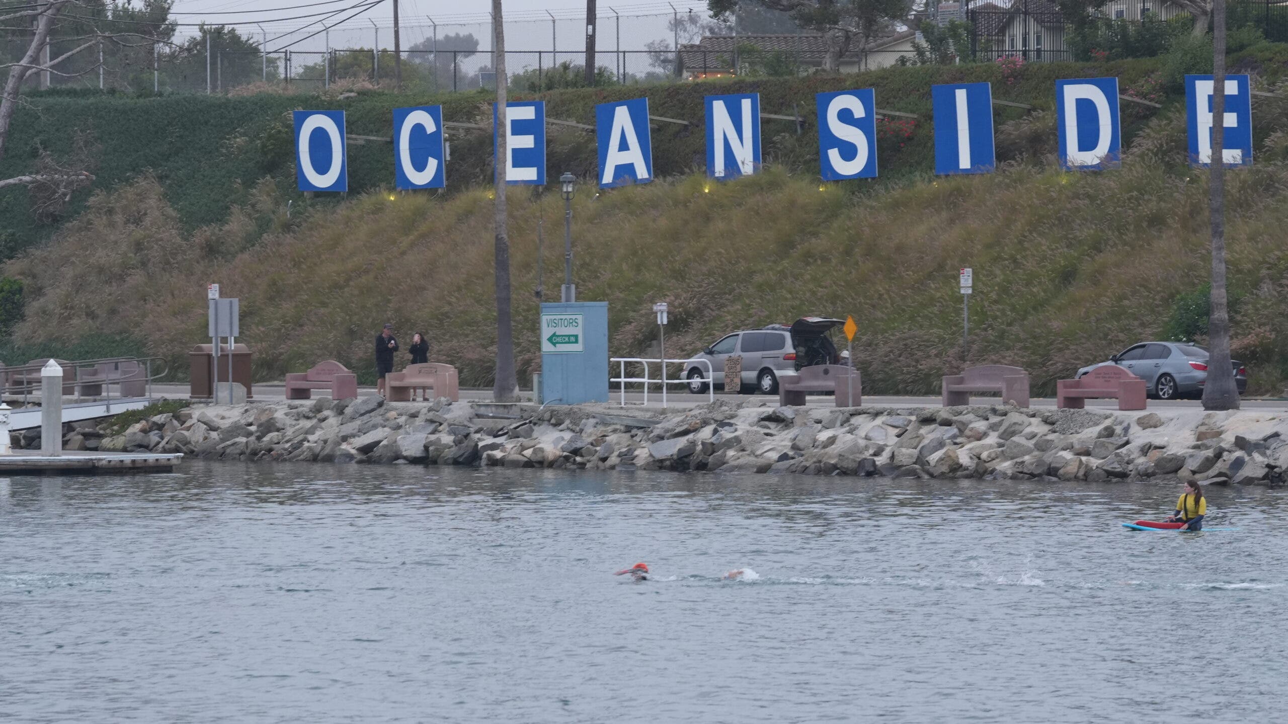 Picture of harbor water and rocks along the water with words "ocean" On the hills