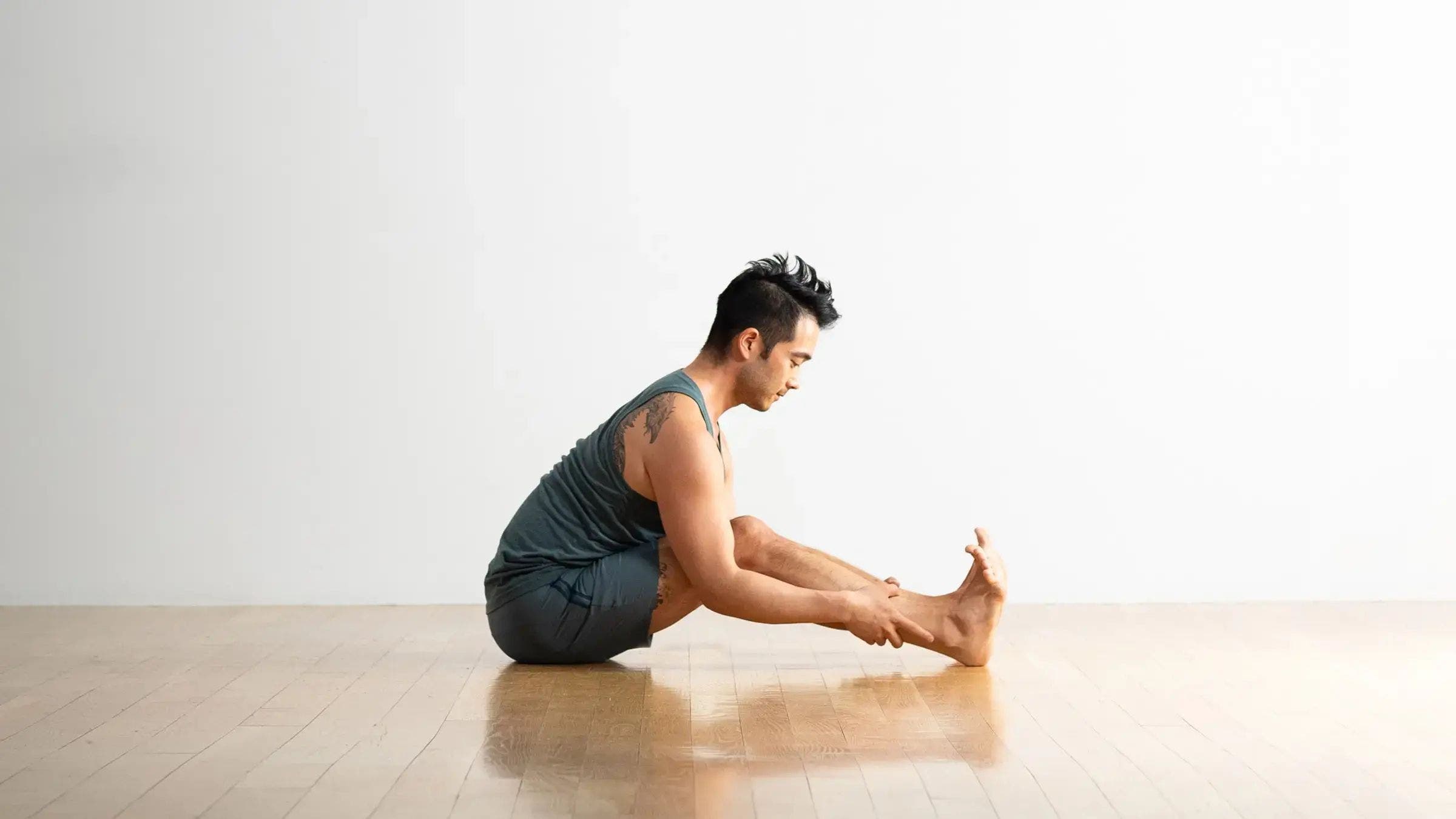 The triathlete performs a modified caterpillar pose in which the knees are bent due to tight hamstrings.