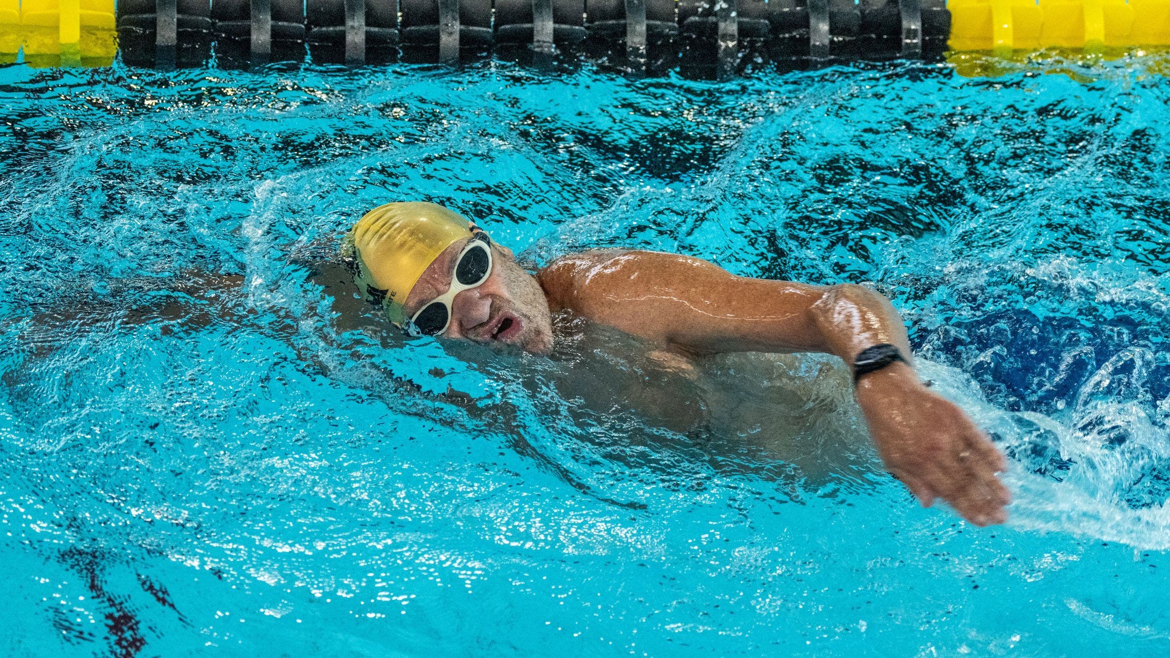 A swimmer rotates to breathe during a freestyle swim stroke.