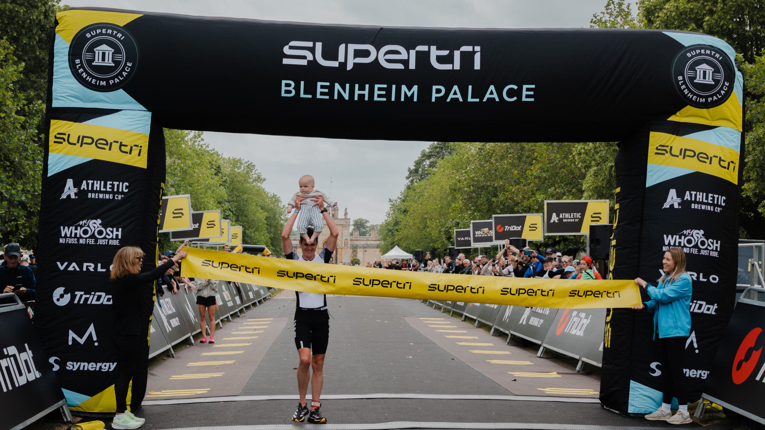 Brownlee crosses the finish line holding his 8-month-old son Freddie.