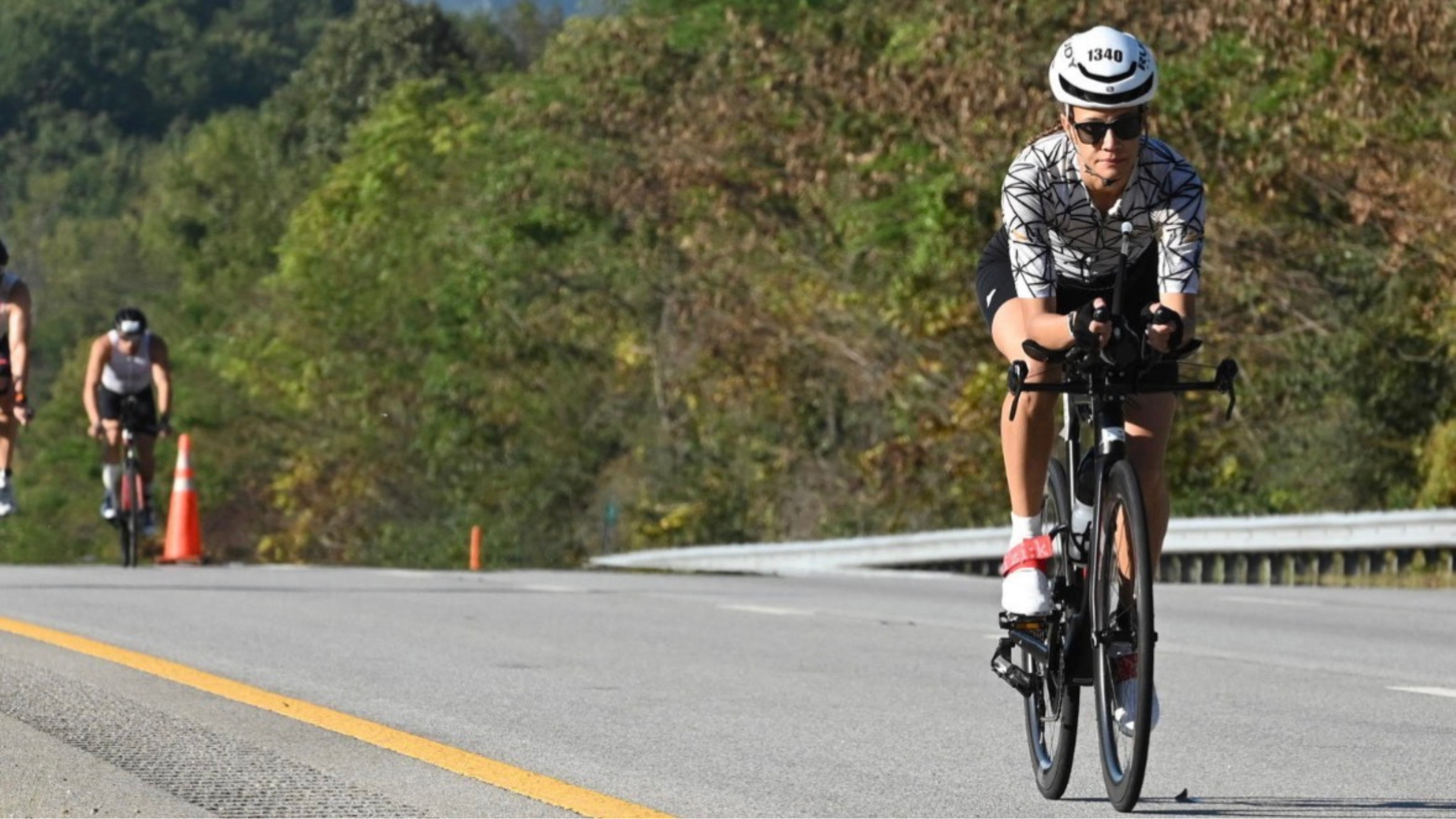 Woman wearing triathlon kit while riding a triathlon bike on the road