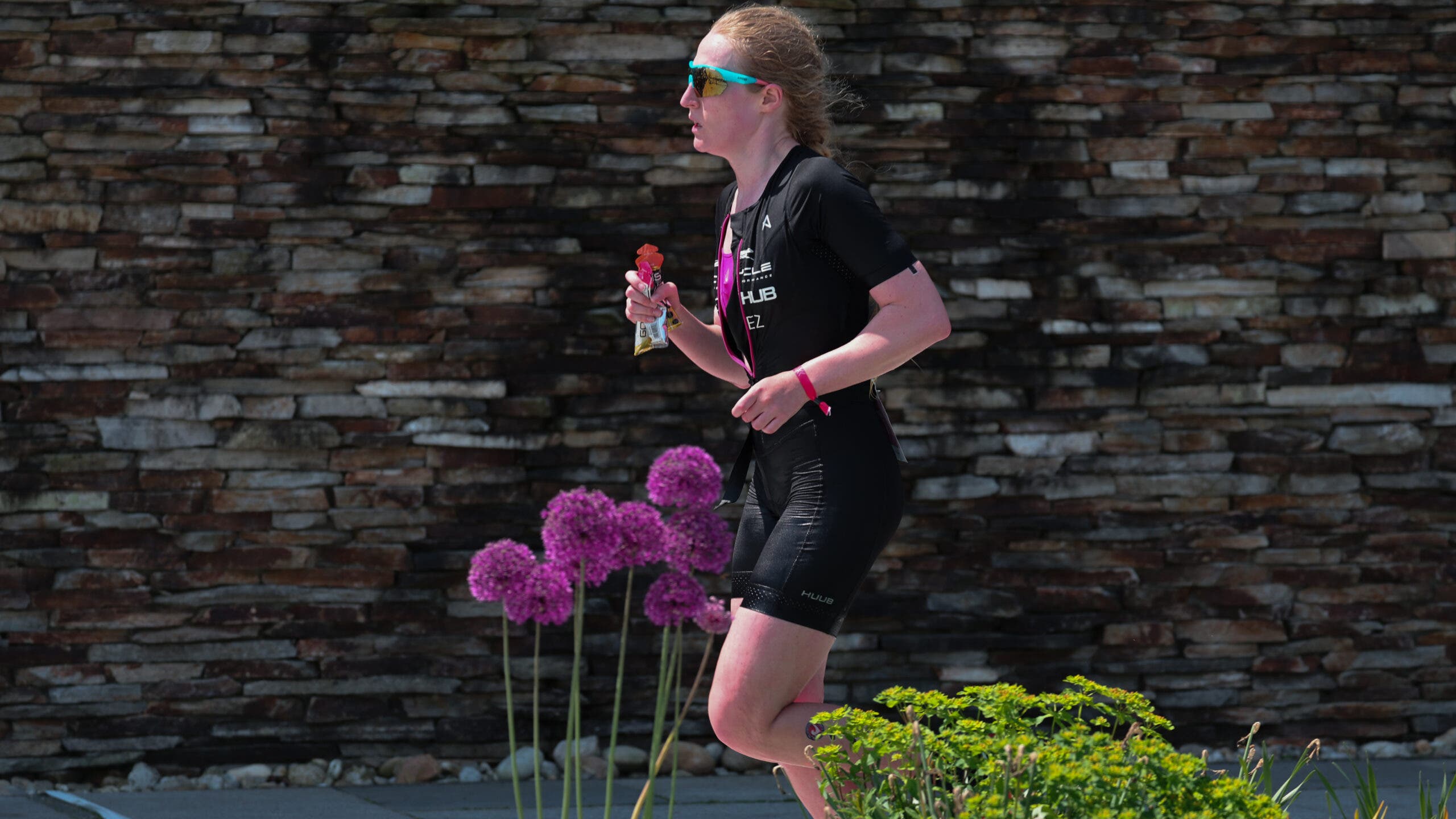 An athlete runs with sports nutrition in her hand.