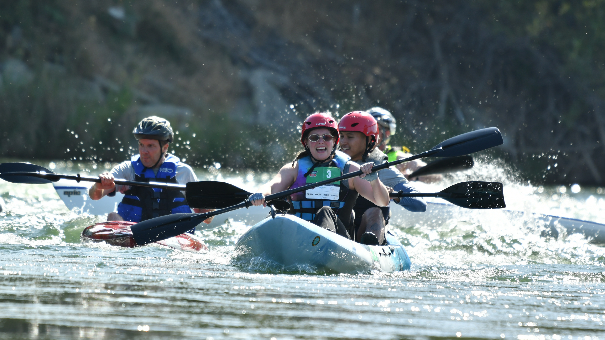 multiple athletes in helmets and vests kayak toward the camera in the Great American Triathlon