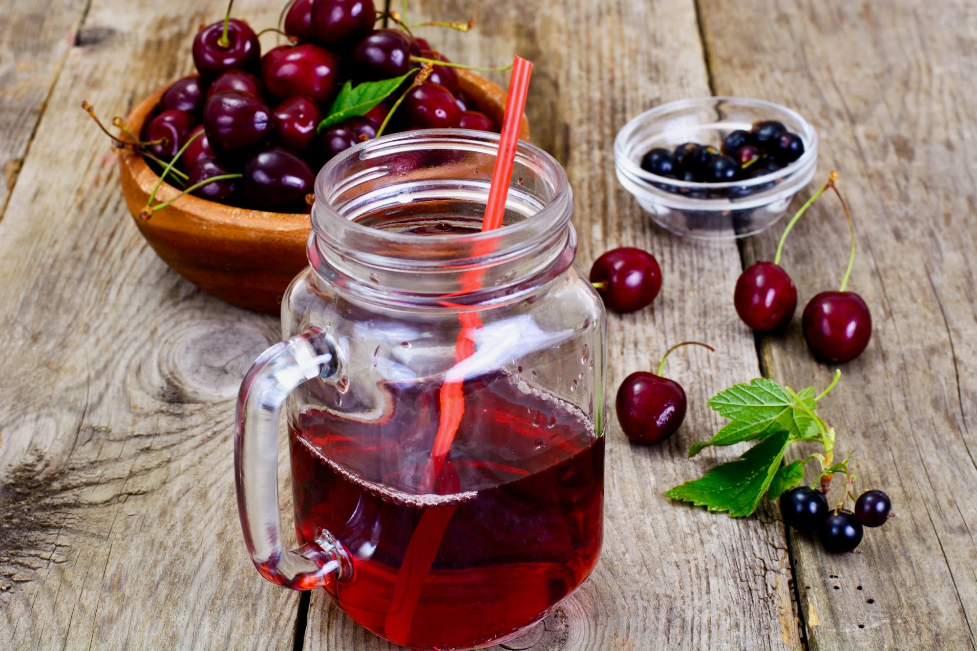 Bowls of berries, an athlete superfood, and mug of tart cherry juice